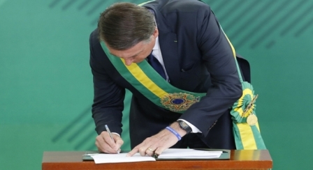 Presidente bolsonaro assinando algo